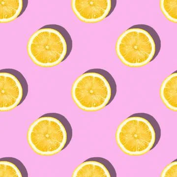 Pattern made of lemon slices on pink background, tropical citrus fruit Stock Photos