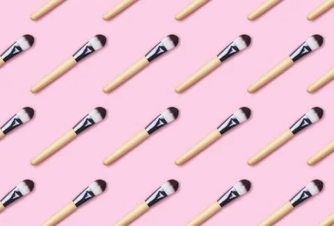 Pattern made from make up brushes on pink background. Stock Photos