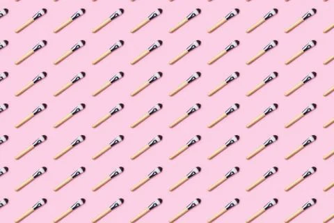 Pattern made from make up brushes on pink background. Stock Photos
