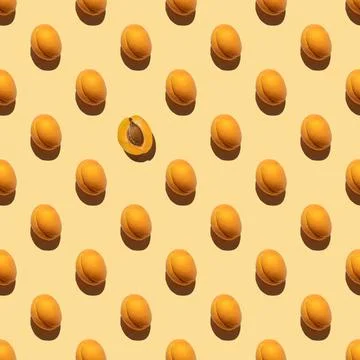 Pattern made with many whole fresh orange apricots isolated on a yellow backg 库存照片