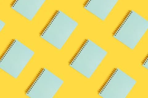 Pattern made of mint spiral copybooks on a yellow background. Stock Photos
