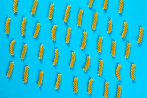 Pattern made of pasta on blue background. Flat lay. Stock Photos