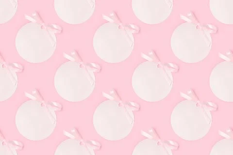 Pattern made of pink round empty tags with tied ribbon bows. Stock Photos