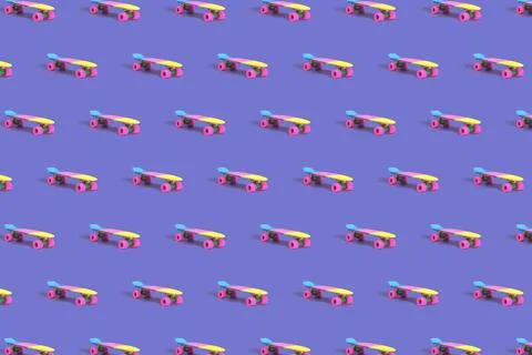 Pattern made of rainbow plastic skateboard on purple background Stock Photos