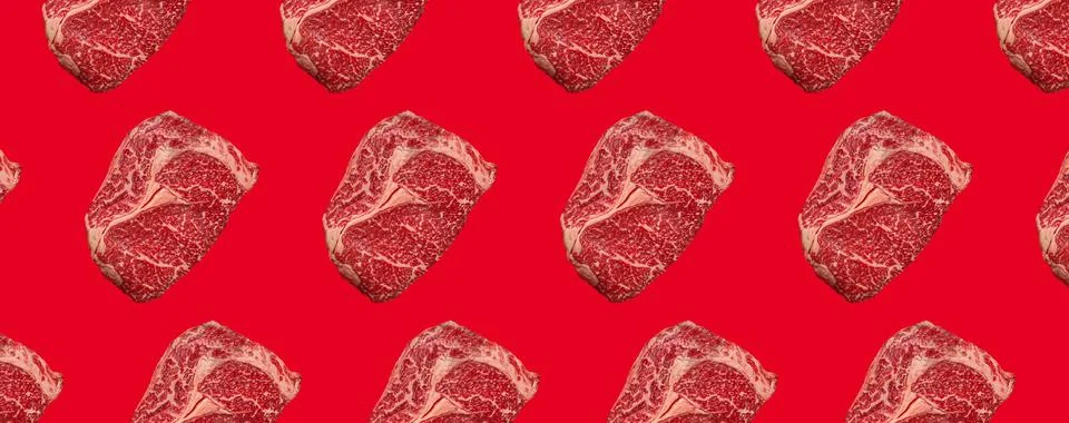 Pattern made of raw meat beef marbled prime cut steak Ribeye on red clean Stock Photos