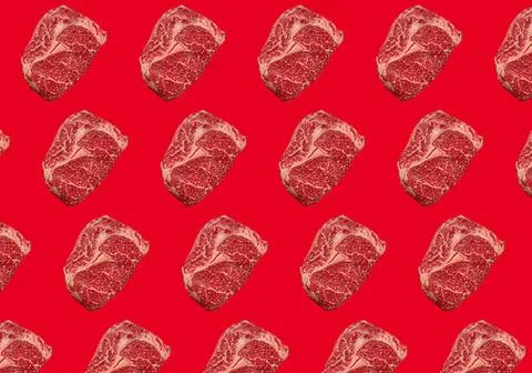 Pattern made of raw meat beef marbled prime cut steak Ribeye on red clean ... Stock Photos