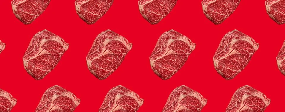 Pattern made of raw meat beef marbled prime cut steak Ribeye on red clean Stock Photos