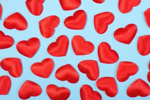 Pattern made of red hearts of the cloth on a pastel blue background Stock Photos