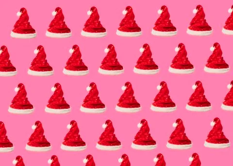 Pattern made of red Santa Claus hat on pink background. Christmas concept. Fl Stock Photos