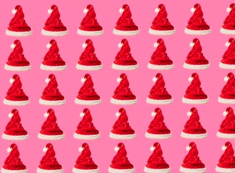 Pattern made of red Santa Claus hat on pink background. Christmas concept. Fl Stock Photos