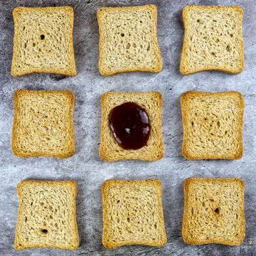A pattern made of rusks including one in the center different because with jam Stock Photos