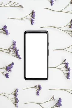 Pattern made of  rustic flowers on table with mockup white screen of smartpho Stock Photos