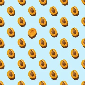 Pattern made with slices of fresh orange apricot isolated on a blue backgroun 库存照片