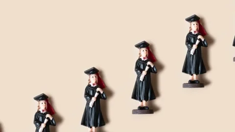 Pattern made from statuette in black graduate hat and gown Stock Footage 239003553