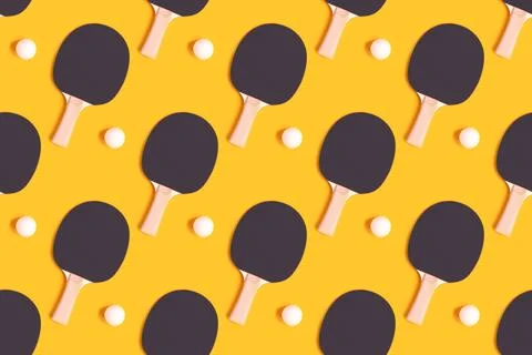 Pattern made of tennis racket and white ball on a yellow background. Stock Photos