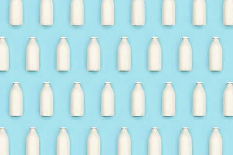 Pattern made with transparent glass bottle of milk on blue background. Flat l Stock Photos
