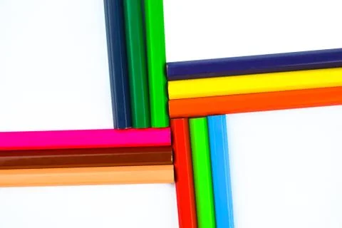 Pattern made with twelve different colored wood pencil crayons placed on a wh Stock Photos