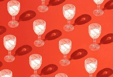 Pattern made of vine glasses fill with white milk fluid and sharp shadow on p Stock Photos