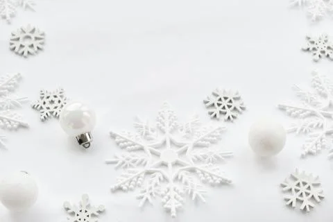 Pattern made of white balls and snowflakes on white background. Stock Photos