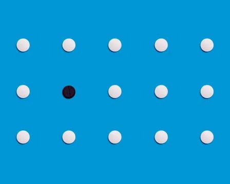 The pattern is made of white pharmaceutical tablets on a blue background. One Stock Photos