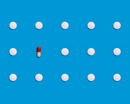 The pattern is made of white pharmaceutical tablets on a blue background. One Stock Photos