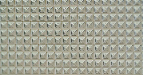 A pattern of many geometric squares on a plexi glass plate, is moving from Video stock 114619841