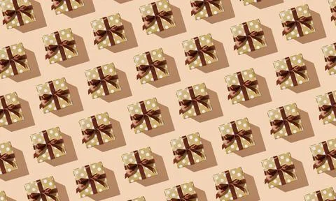 Pattern of many gift boxes with polka dots and brown ribbons on a beige backg 스톡 사진