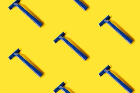 Pattern of many plastic blue shaver razors on yellow background Stock Photos
