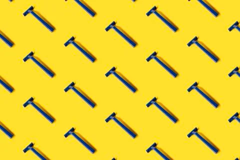Pattern of many plastic blue shaver razors on yellow background Stock Photos