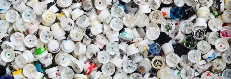 A pattern of many used and soiled nozzles from spray cans with aerosol paint. Stock Photos