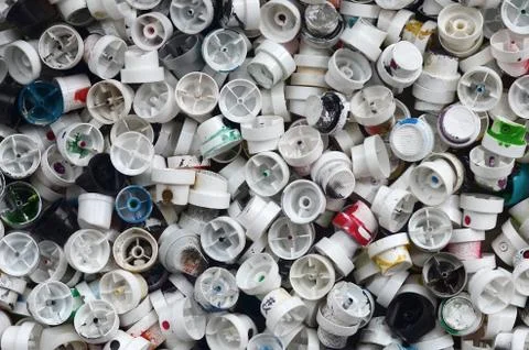 A pattern of many used and soiled nozzles from spray cans with aerosol paint. Stock Photos