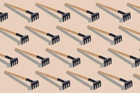 Pattern with metal rake isolated on light brown background Stock Photos