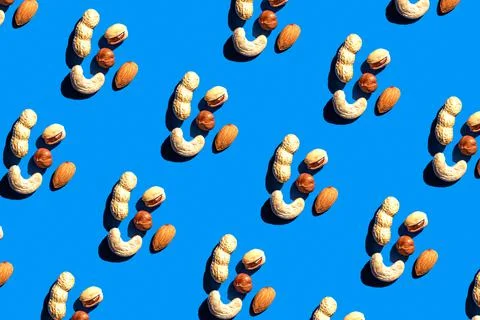 Pattern from mix nuts on blue background. Pattern from different nuts. Trendy Stock Photos