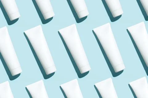 Pattern from mock up cosmetic or toothpaste tubes on blue background Stock Photos