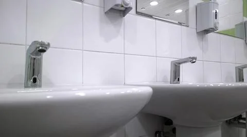 Pattern of modern white bathroom sink and faucet in public toilet Stock Photos