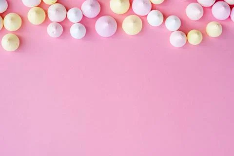 Pattern of multicolored meringue on the edge of pink background Stock Photos