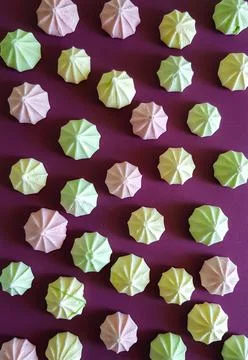 A pattern of multicolored meringues on a purple background Stock Photos