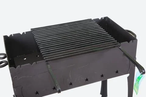 Pattern of new metal brazier with grill for barbecue closeup Stock Photos