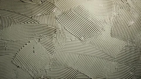 Pattern of notched trowel strokes on the gray surface of cement putty for laying Stock Footage 227569765
