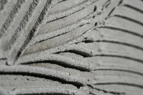 Pattern of notched trowel strokes on the gray surface of cement putty for laying Stock Photos