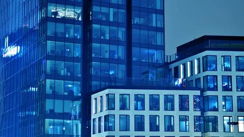 Pattern of office buildings windows illuminated at night. Stock Photos