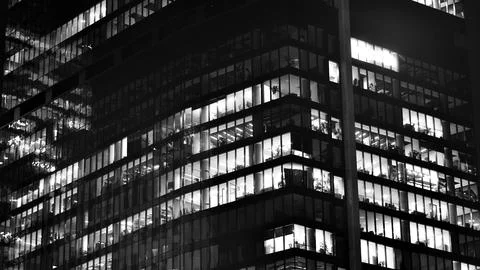 Pattern of office buildings windows illuminated at night. Stock Photos