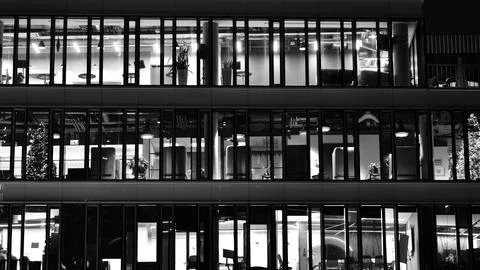 Pattern of office buildings windows illuminated at night. Stock Photos