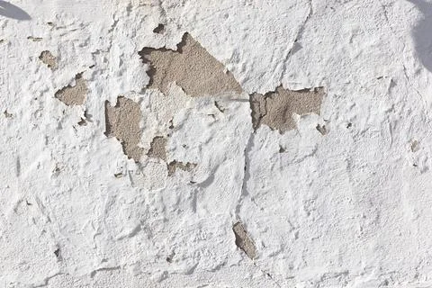 Pattern ofold rough plaster wall with white paint peeling, symbolizing age .. Stock Photos