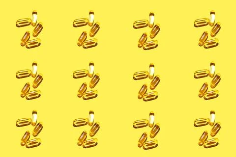 Pattern from omega vitamins with hard light on a yellow background. Yellow ov Stock Photos