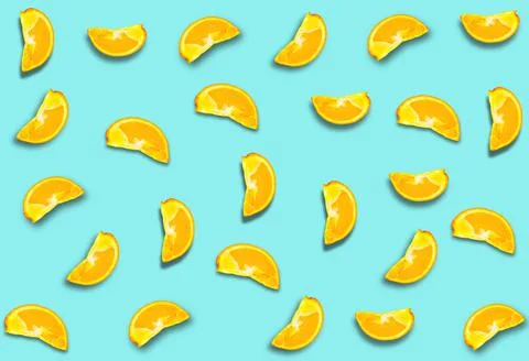 A pattern of orange slices with a shadow on a blue background. Fruit backgrou Stock Photos