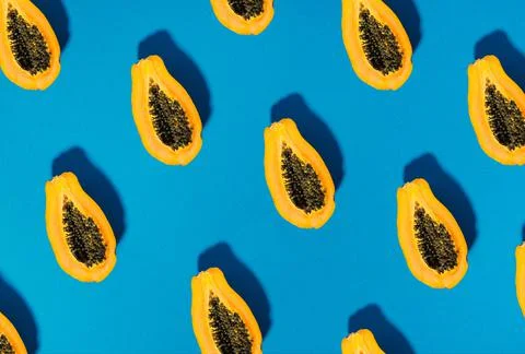 Pattern of papaya fruit cutted on half on blue background Foto stock