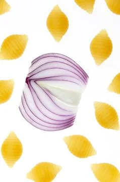 A pattern of pasta and red onion on a white background close-up. Stock Photos