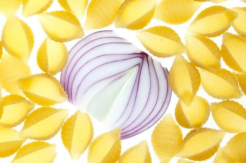 A pattern of pasta and red onion on a white background close-up. Stock Photos