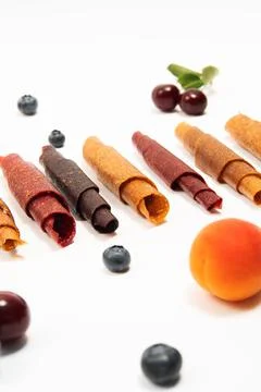 Pattern pastila fruit leather rolls up with fruits on white background. Vertical Stock Photos